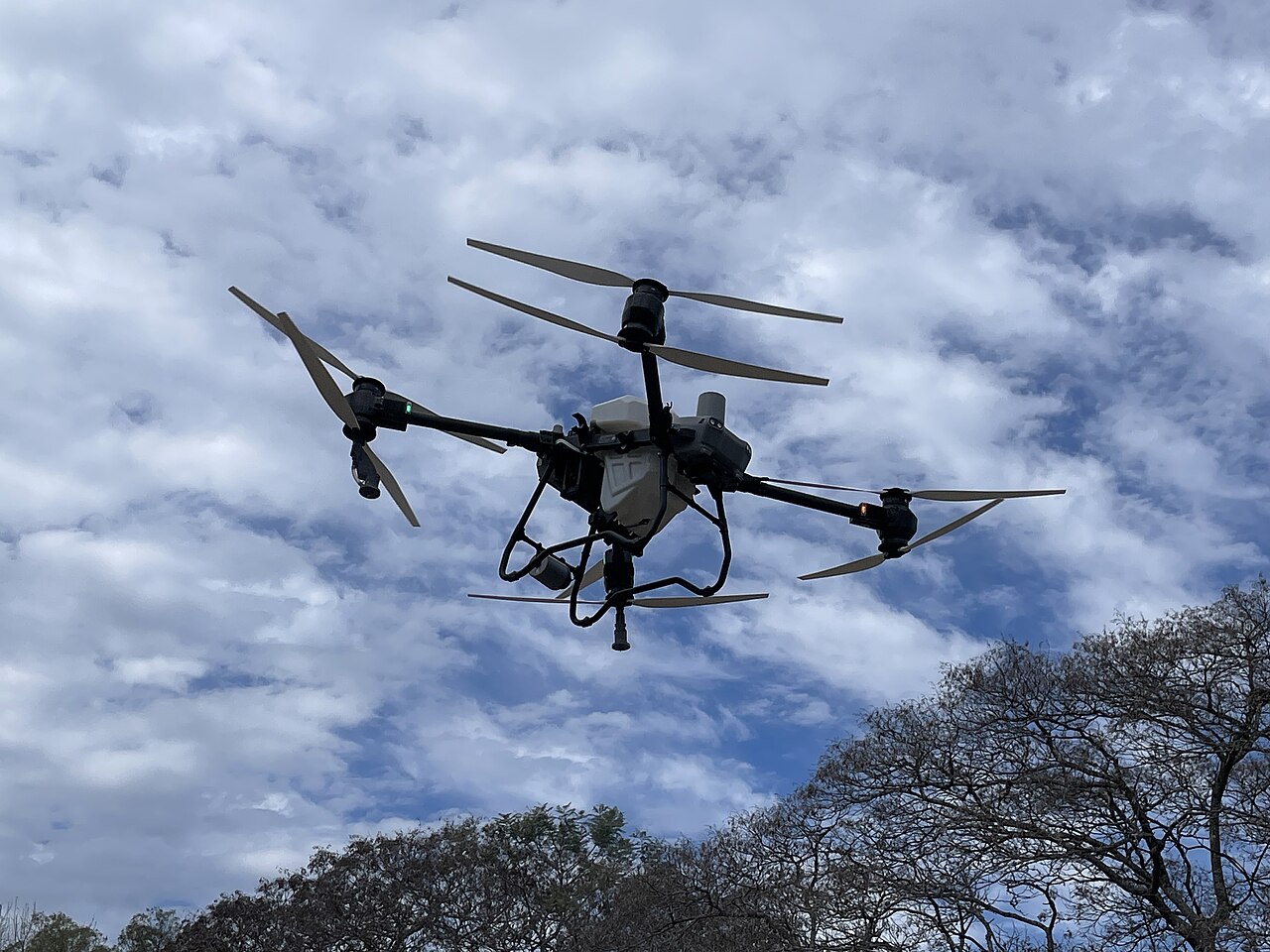 A DJI Agras T50 agricultural drone in flight during a 2025 demonstration.